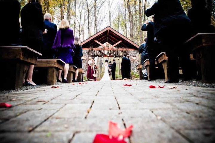 Stroudsmoor Country Inn - Stroudsburg - Poconos - Woodlands Outdoor Wedding - Wedding Couple Under Outdoor Chapel Joined By Wedding Party