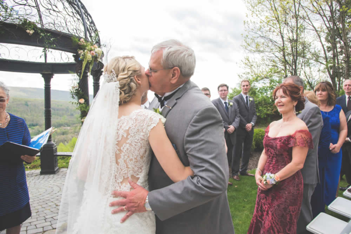 Father kissing bride at wedding ceremony