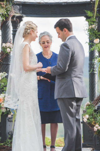 Groom putting ring on bride's finger