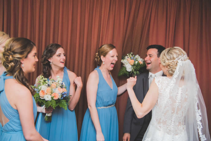 Bride, groom, and bride's maids excited