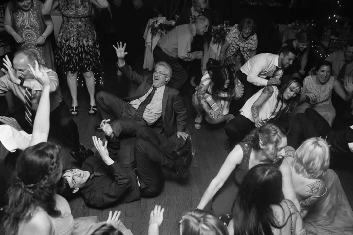 wedding event Black and white photo of wedding guests dancing. Some of them are on the floor.