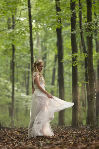 wedding event A bride spins in circles outside, swirling her dress amongst the forest.