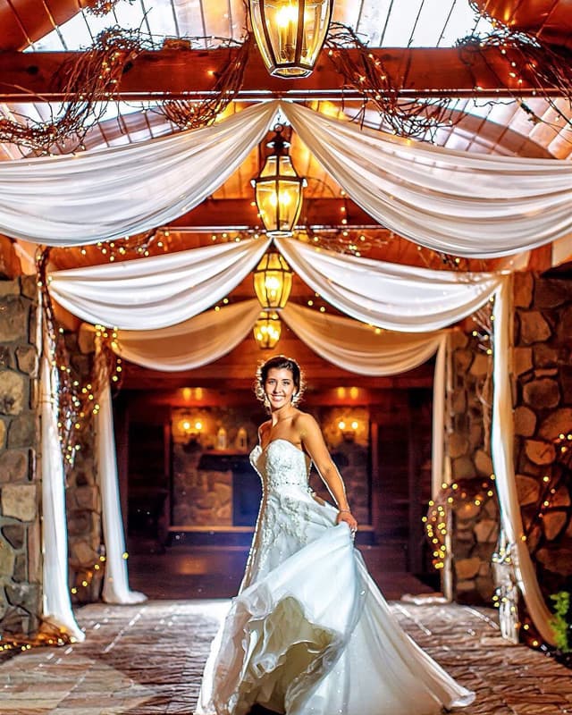 Bride twirling under drapes of sheer fabric and light