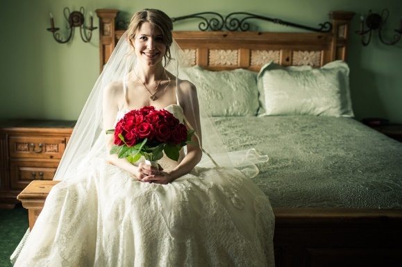 Bride sitting holding a bouquet of roses