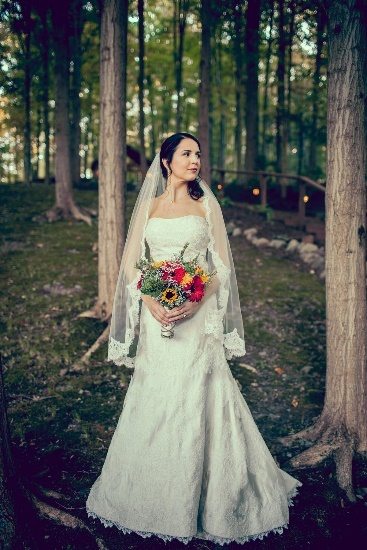 Bride in woods with bouquet of flowers