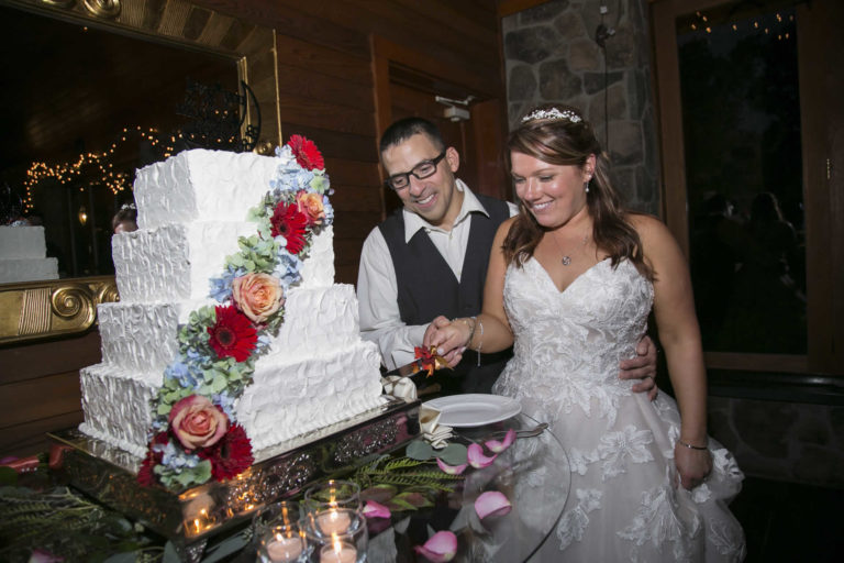 Bride and groom cutting wedding cake as couple lawnhaven