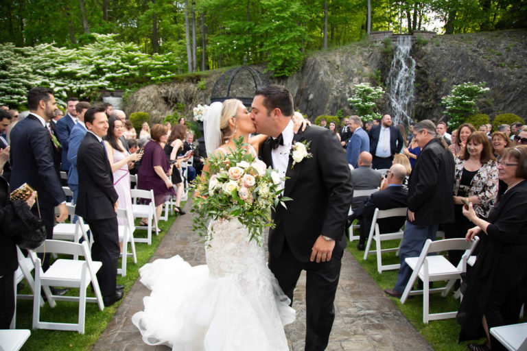 Bride and groom walking back down isle as married couple terraview