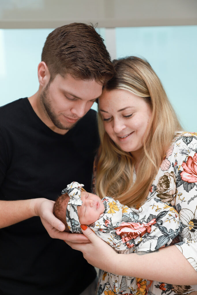 New mom and dad gaze down at newborn baby girl