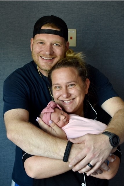 New mother and father hold infant baby girl