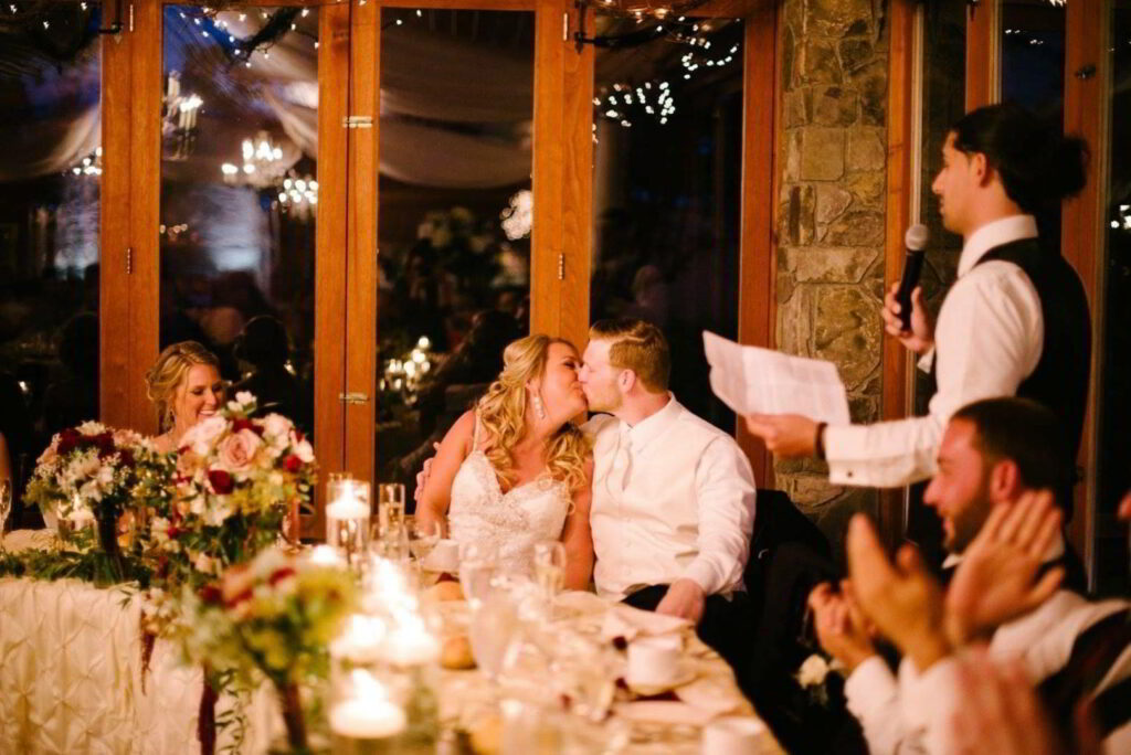 Bride and groom kiss at sweetheart table