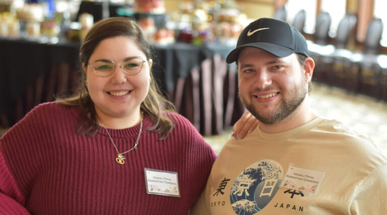 Couple smiles with arms around each other