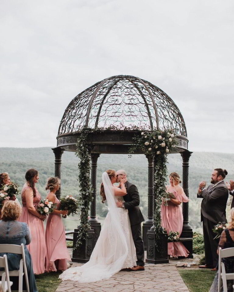 Client Accolades 8 Wedding couple kissing under a scenic gazebo - getting married