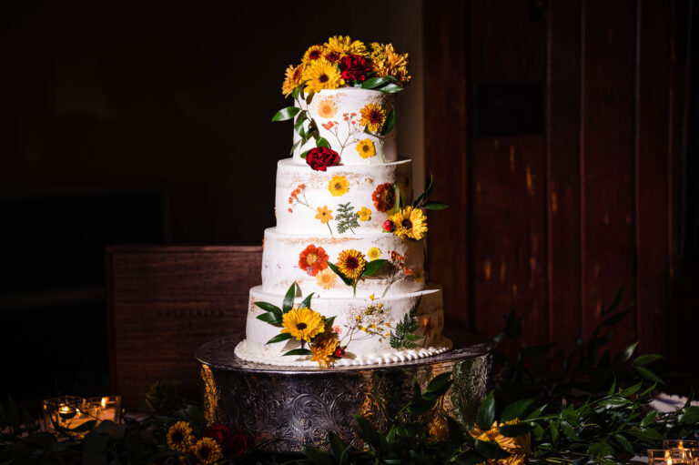Fresh and dry flowers adorn four-tier wedding cake