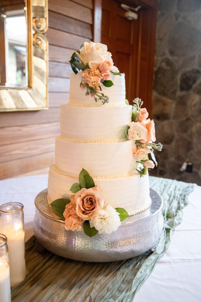 Pink florals adorn four-tier wedding cake