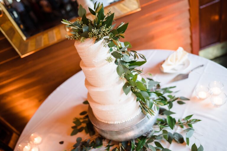 Four-tiered wedding cake complete with greenery