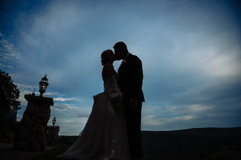 Bride and Groom silhouetted against blue sky