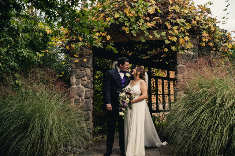 Bride and groom beneath Lawnhaven trellis