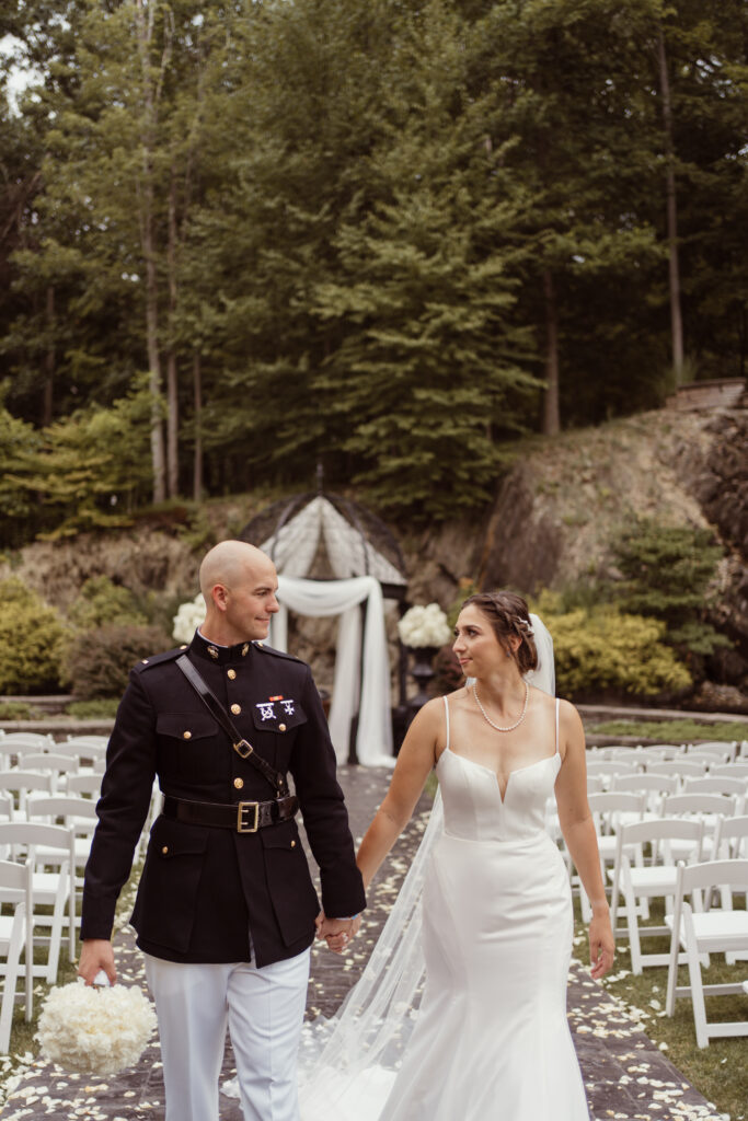 Groom and bride hold hands and walk up Terraview ceremony aisle