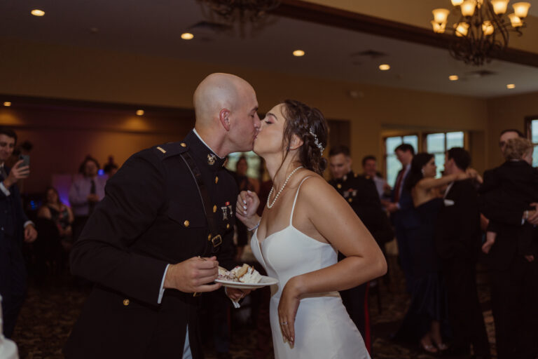 Bride and groom kiss after cutting cake