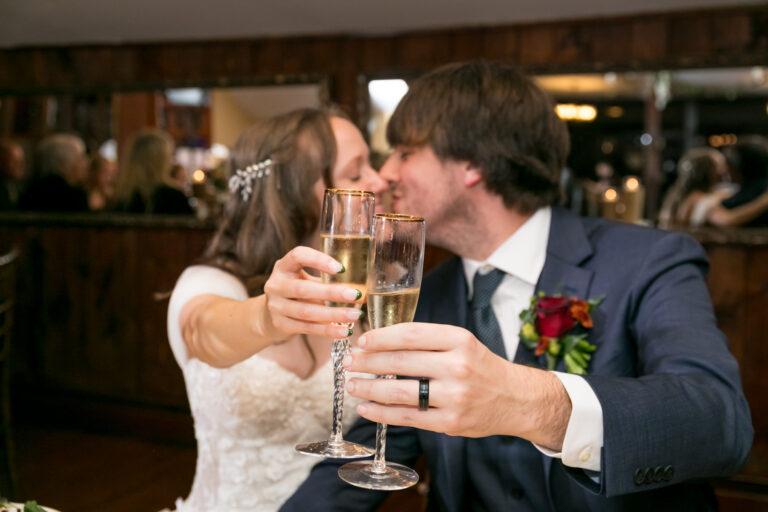 Bride and groom share toast while kissing