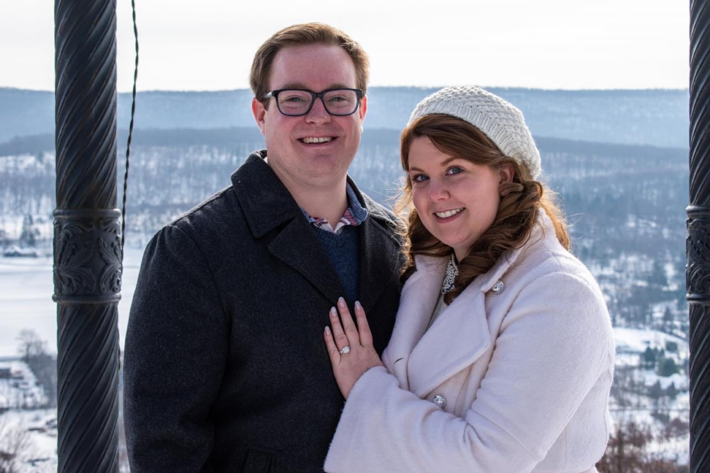 Couple smiles in front of mountain backdrop