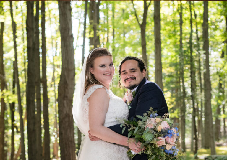 Bride and groom embrace beneath Woodgate chapel