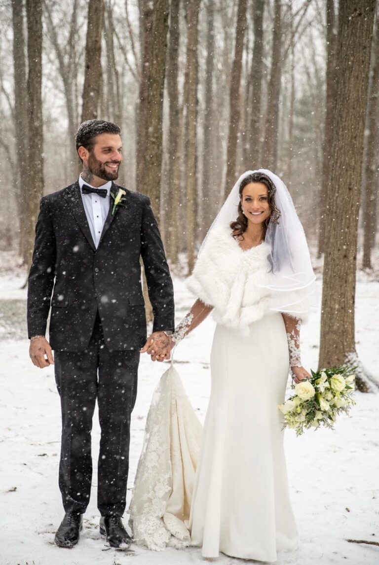 Bride and groom hold hands in the snow
